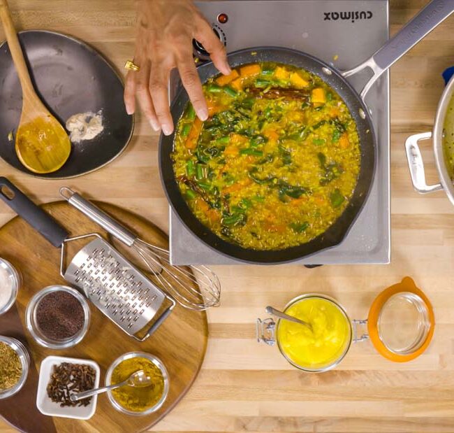 View from above of someone making kitchari in a kitchen with cooking utensils and ingredients