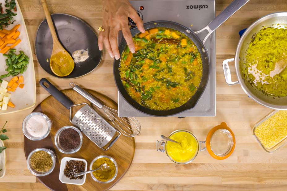 View from above of someone making kitchari in a kitchen with cooking utensils and ingredients