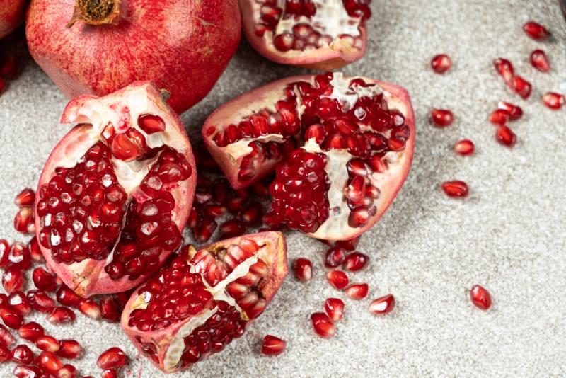 An open pomegranate on a stone surface.
