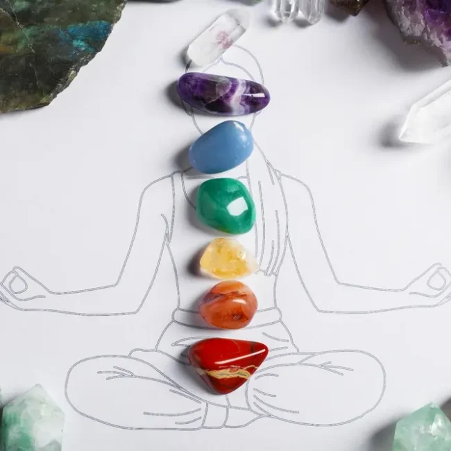 Drawing of a person with colored gemstones placed over the chakras.