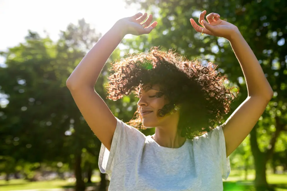 A young woman enjoys dancing outdoors.