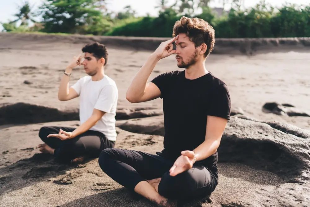 Two men outdoors practicing alternate nostril breathing