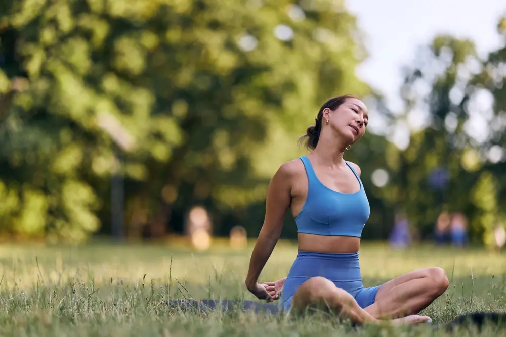 A woman practicing outdoor yoga for alignment with nature in the morning.