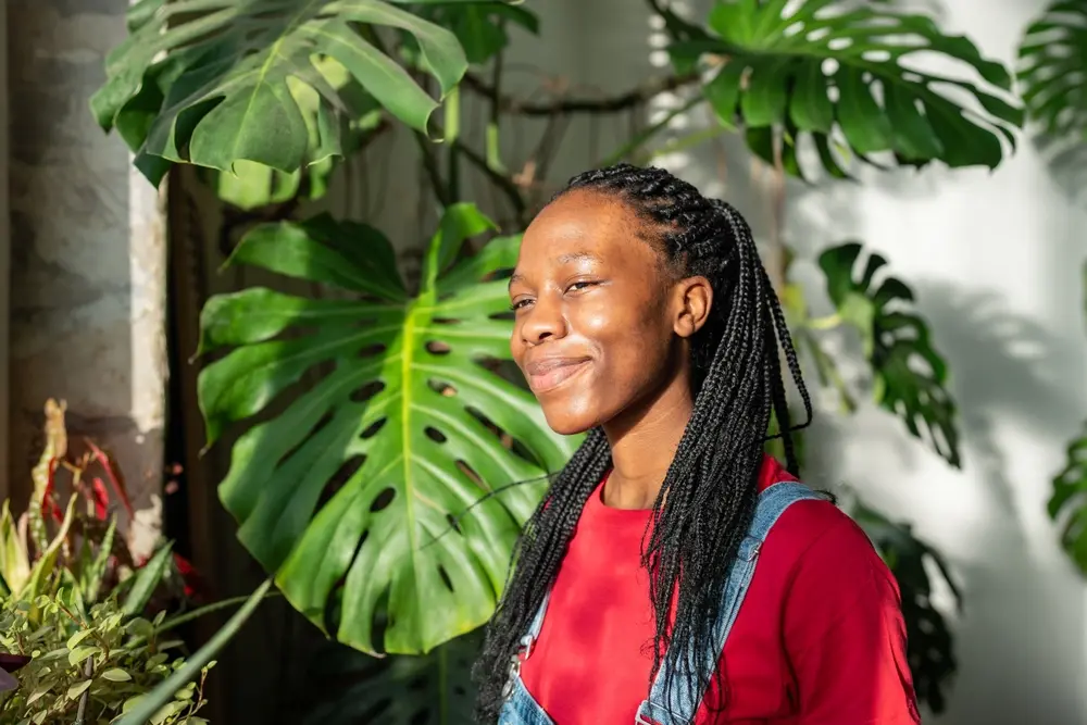 A young woman smiling in the sunshine for circadian rhythm alignment.