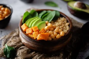 A bowl of spinach, quinoa, sweet potato, and avocado