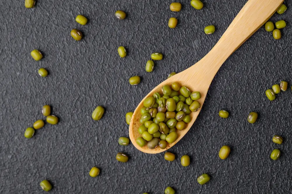 Mung beans on a wooden spoon